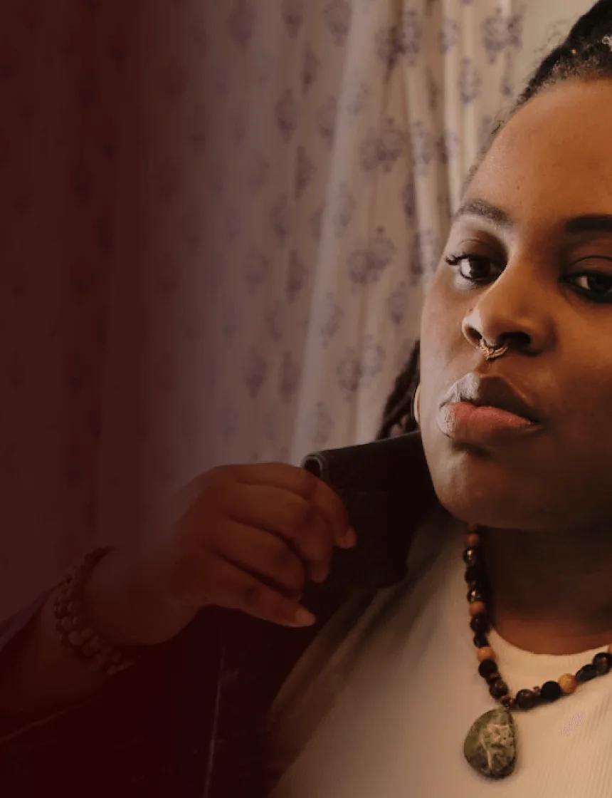Woman with narcolepsy type 1 fixing her collar in a bathroom mirror