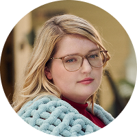 Woman with narcolepsy type 1 posing outdoors while wrapped in a knitted blanket
