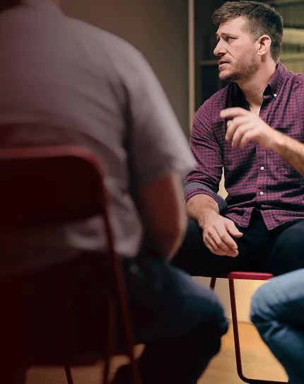 Man with narcolepsy type 1 sitting in a chair and talking in a support group