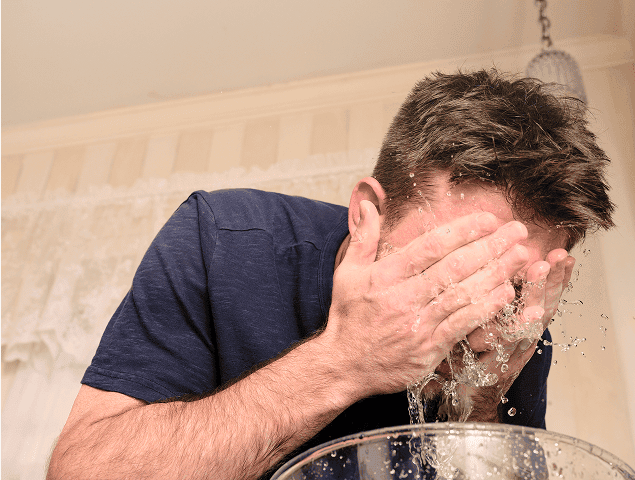 Man with narcolepsy type 1 splashing cold water on his face