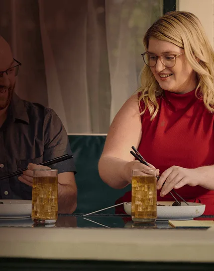Woman with narcolepsy type 1 sitting at a table and eating with her partner