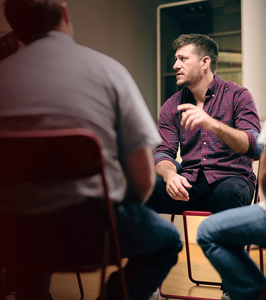 Man with narcolepsy type 1 sitting in a chair and talking in a support group
