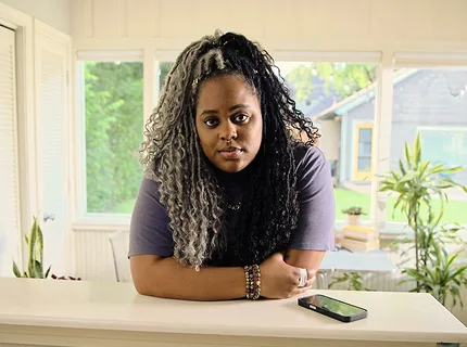 Woman with narcolepsy type 1 posing with her arms crossed over a counter